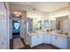 Bathroom featuring double sinks, elegant lighting, and a glimpse into the bedroom at 32937 Scenic Hills Dr, Mount Dora, FL 32757
