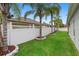 Beautiful backyard featuring a well-maintained lawn, white fence, and stately palm trees at 3813 Blue Dasher Dr, Kissimmee, FL 34744
