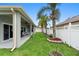 Well-maintained backyard with a covered patio, green grass, and beautiful palm trees at 3813 Blue Dasher Dr, Kissimmee, FL 34744