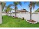 Lush backyard with white picket fence, green grass, and attractive landscaping at 3813 Blue Dasher Dr, Kissimmee, FL 34744