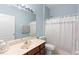 Bathroom features a single sink vanity, a large mirror, toilet, and shower with patterned curtain at 3813 Blue Dasher Dr, Kissimmee, FL 34744