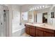 Bathroom featuring double sinks, soaking tub, and a shower with glass door at 3813 Blue Dasher Dr, Kissimmee, FL 34744