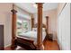 Bedroom featuring a four-poster bed, hardwood floors, and a view of the neighborhood at 3813 Blue Dasher Dr, Kissimmee, FL 34744