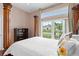 Bedroom with hardwood floors, a four-poster bed, and natural light from a large window at 3813 Blue Dasher Dr, Kissimmee, FL 34744