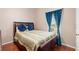Cozy bedroom featuring a comfortable bed and bright window with blue curtains at 3813 Blue Dasher Dr, Kissimmee, FL 34744
