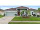 Charming home with a well-kept lawn, red front door, and a two-car garage at 3813 Blue Dasher Dr, Kissimmee, FL 34744