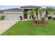 Charming single-story home featuring a red front door, palm trees, and manicured lawn at 3813 Blue Dasher Dr, Kissimmee, FL 34744