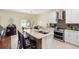 Modern kitchen with stainless steel appliances, white cabinetry, tile backsplash and an island with bar seating at 3813 Blue Dasher Dr, Kissimmee, FL 34744