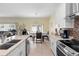 Bright kitchen featuring white cabinets, granite countertops, stainless steel appliances, tile backsplash and breakfast nook at 3813 Blue Dasher Dr, Kissimmee, FL 34744