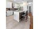 Modern kitchen island with seating, featuring white cabinetry and stainless steel appliances at 3813 Blue Dasher Dr, Kissimmee, FL 34744