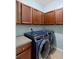 Clean laundry room with modern washer and dryer, and cabinet space for storage at 3813 Blue Dasher Dr, Kissimmee, FL 34744