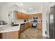Well-lit kitchen features wood cabinets, stainless steel appliances, light countertops, and wood-look flooring at 4110 Boca Woods Dr, Orlando, FL 32826