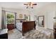 Bedroom featuring a ceiling fan, large window, and ensuite bathroom at 4110 Boca Woods Dr, Orlando, FL 32826