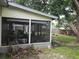 View of the home's screened porch with outdoor seating and view of the backyard at 4123 Gander Ave, Orlando, FL 32822
