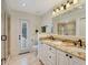 Bright bathroom featuring a double vanity, granite countertops, and access to an outdoor area at 4454 Aspenwood Ct, Orlando, FL 32835
