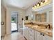 Bright bathroom featuring a double vanity, granite countertops, and access to an outdoor area at 4454 Aspenwood Ct, Orlando, FL 32835