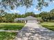 Home with a long paved driveway leading to a modern, well-manicured property at 4454 Aspenwood Ct, Orlando, FL 32835