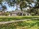 Stunning single-story home featuring a modern black and white design and lush green lawn at 4454 Aspenwood Ct, Orlando, FL 32835