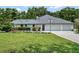 Spacious home featuring an attached garage, expansive driveway, manicured lawn, and mature trees at 4454 Aspenwood Ct, Orlando, FL 32835