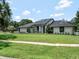 Beautiful exterior elevation of the home, enhanced by a lush green lawn, modern design and mature landscaping at 4454 Aspenwood Ct, Orlando, FL 32835