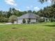 Side view of the house showing lawn, landscaping, a driveway leading to garage and the architectural details at 4454 Aspenwood Ct, Orlando, FL 32835