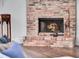 Cozy brick fireplace with a lit fire, complemented by hardwood floors at 4454 Aspenwood Ct, Orlando, FL 32835