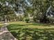 Expansive front lawn featuring lush grass, mature trees, and a curved walkway at 4454 Aspenwood Ct, Orlando, FL 32835