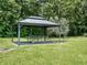 Outdoor gazebo featuring a metal roof and frame offering shade over a picnic table and bench on the lawn at 4454 Aspenwood Ct, Orlando, FL 32835