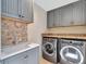 Modern laundry room equipped with matching washer and dryer and ample cabinet space at 4454 Aspenwood Ct, Orlando, FL 32835