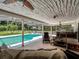 Elegant outdoor living space featuring a sparkling pool, covered patio, and outdoor kitchen, seamlessly connected at 4454 Aspenwood Ct, Orlando, FL 32835