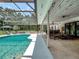 Covered outdoor patio with travertine floors overlooks the pool and features an outdoor kitchen and dining area at 4454 Aspenwood Ct, Orlando, FL 32835