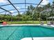 A refreshing pool surrounded by a screened enclosure, offering a serene view of the well-maintained backyard at 4454 Aspenwood Ct, Orlando, FL 32835