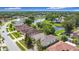 Aerial view of a residential neighborhood with houses surrounding a serene pond at 451 Acacia Tree Way, Kissimmee, FL 34758