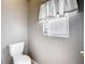 Cozy powder room features a toilet and window for natural light and ventilation at 451 Acacia Tree Way, Kissimmee, FL 34758