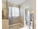 Bright bathroom features a shower with neutral tile and a separate toilet room at 451 Acacia Tree Way, Kissimmee, FL 34758