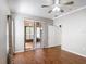 Bedroom with wood floors, ceiling fan, and sliding glass doors to the outside at 451 Acacia Tree Way, Kissimmee, FL 34758