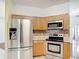 Kitchen featuring stainless steel appliances and wooden cabinetry at 451 Acacia Tree Way, Kissimmee, FL 34758