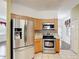 Well-equipped kitchen featuring stainless steel appliances and tile backsplash at 451 Acacia Tree Way, Kissimmee, FL 34758