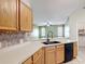 Functional kitchen with wood cabinets, black appliances, and tiled backsplash at 451 Acacia Tree Way, Kissimmee, FL 34758