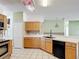 Kitchen showcasing wooden cabinets, black appliances, and tiled flooring at 451 Acacia Tree Way, Kissimmee, FL 34758