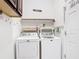 Laundry room with white washer and dryer and a decorative shelf above at 451 Acacia Tree Way, Kissimmee, FL 34758