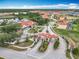 Beautiful aerial view of a community with red-tiled roofs, a lake, and palm trees surrounding the entrance at 512 Viola Dr, Davenport, FL 33837