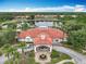 Aerial view of the clubhouse with a red tile roof overlooking the lake and fountain at 512 Viola Dr, Davenport, FL 33837