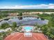 Overhead shot of the lake and neighborhood showcasing the pool, clubhouse, and tile roofs at 512 Viola Dr, Davenport, FL 33837
