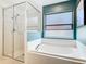 Bathroom featuring a bathtub, shower, window, and a blue accent wall at 512 Viola Dr, Davenport, FL 33837