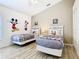 Themed bedroom featuring two beds with wall decor and light wood flooring at 512 Viola Dr, Davenport, FL 33837