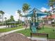 Well-maintained playground with green turf, playground equipment, benches, and a gazebo overlooking palm trees at 512 Viola Dr, Davenport, FL 33837