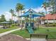 Fun playground featuring slides, climbing structures, and shade, surrounded by lush landscaping and palm trees at 512 Viola Dr, Davenport, FL 33837