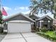 Charming home exterior with well-manicured lawn, mature landscaping and two car garage at 545 Hardwood Cir, Orlando, FL 32828