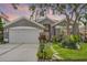 Charming gray home with a well-manicured lawn, garden, and lovely trees at 545 Hardwood Cir, Orlando, FL 32828